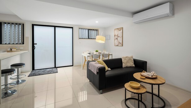 A modern living room with a black sofa, a small round table, and a dining area with a white table and chairs. - Smart Suites Self Check-in Apartments - 144 Dixon (Sunnybank)