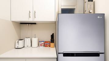 A modern kitchen with a stainless steel refrigerator, a microwave, and a toaster.