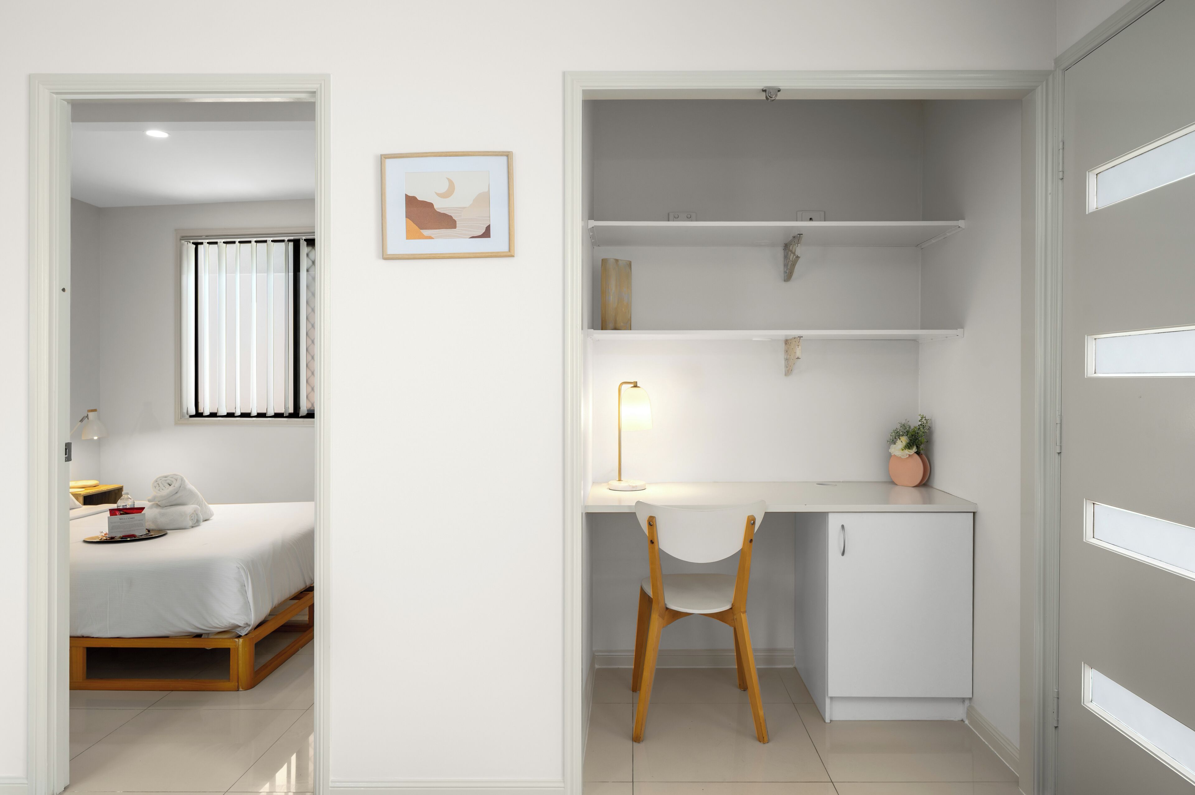 Une chambre à coucher avec un lit, une table de chevet et une fenêtre avec des stores.