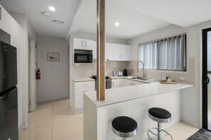 Fridge, microwave, stovetop, cookware/dishes/utensils - Smart Suites Self Check-in Apartments - 144 Dixon (Sunnybank)