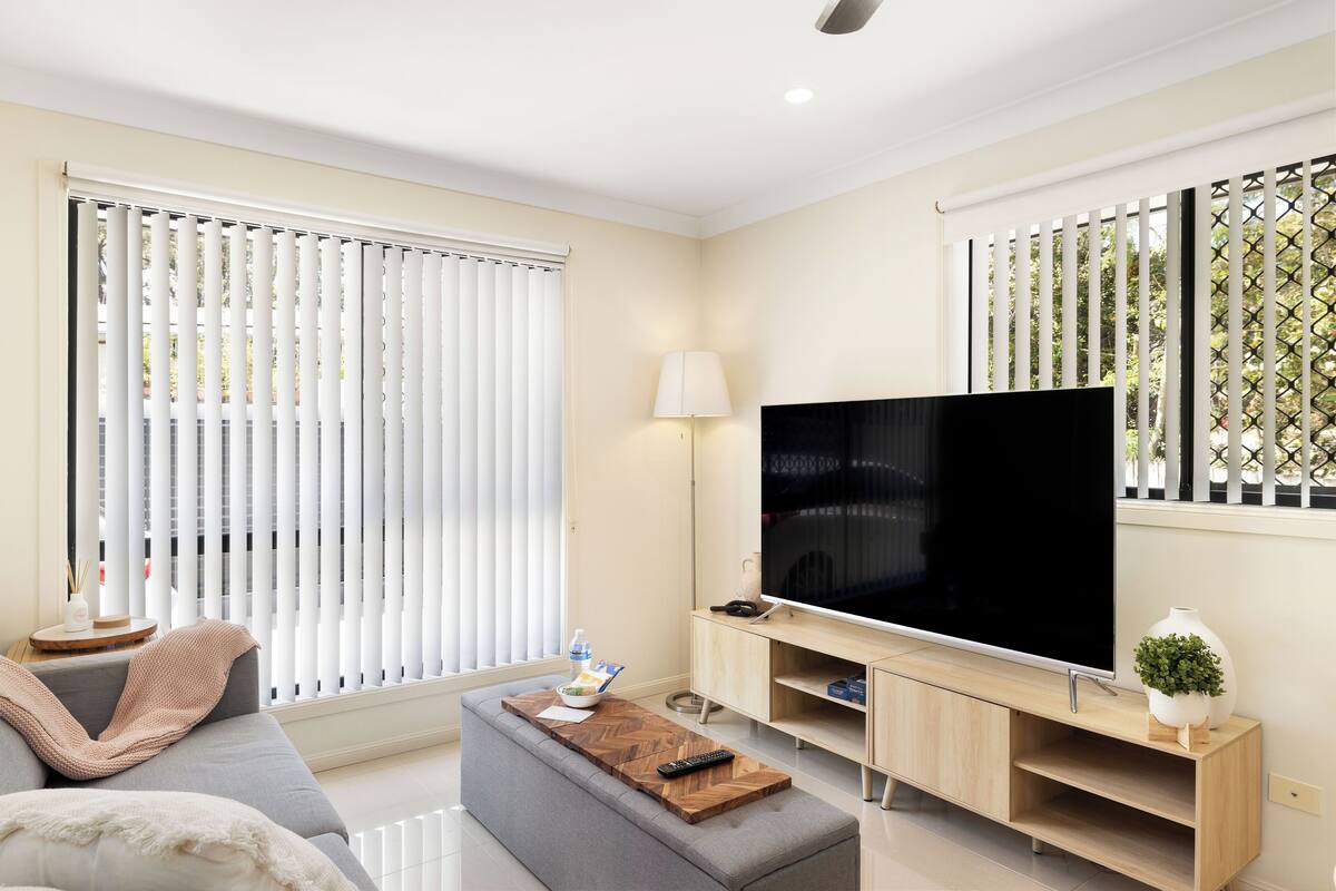 A modern living room with a sofa, a coffee table, a TV, and a lamp.