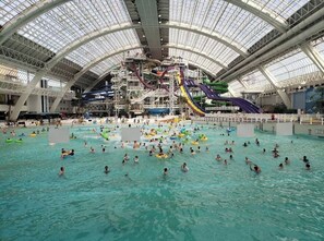 Ein großer, überdachter Wasserpark mit mehreren Rutschen und Becken.