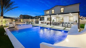 Une maison moderne dotée d’une piscine, de mobilier d’extérieur et d’un espace patio.