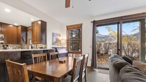 Une cuisine moderne avec des meubles en bois et un coin repas comprenant une grande table et des chaises.