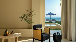 A room with a view of the sea, a round table with fruit, a wicker chair, and a small table with decorative items. - Miyue Roman Holiday Bubble Pool hotel (Shenzhen)