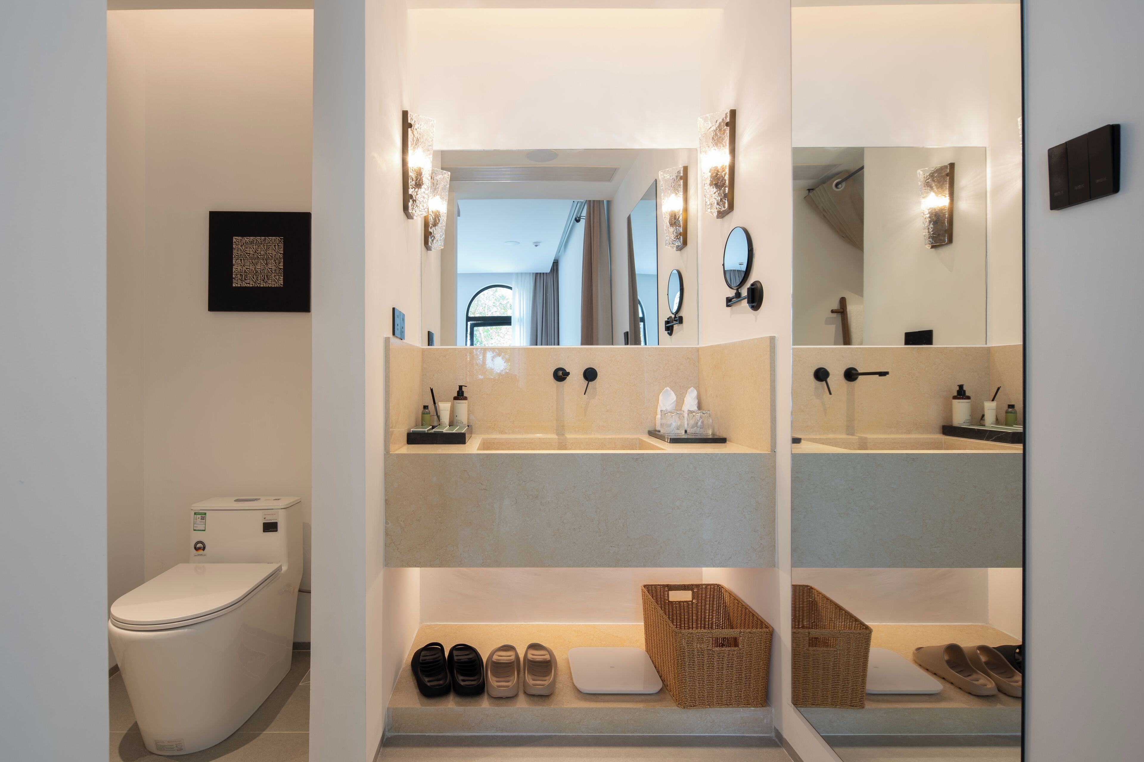 Un baño moderno con inodoro, dos lavamanos y un espejo.