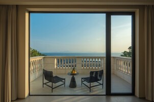 Ένα μπαλκόνι με ένα τραπέζι και δύο καρέκλες, από το οποίο μπορεί κανείς να απολαύσει την υπέροχη θέα στη θάλασσα.
