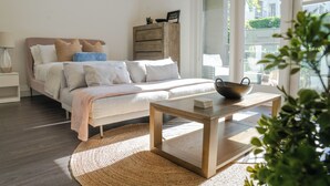 A bedroom with a bed, bedside table, and a view of the outside. - Modern studio apartment with roof top, WiFi, AC in enjoyable Irvine (Irvine)