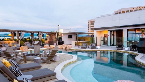 A rooftop pool area with lounge chairs and a building labeled "K&L Gates". - Modern studio apartment with roof top, WiFi, AC in enjoyable Irvine (Irvine)