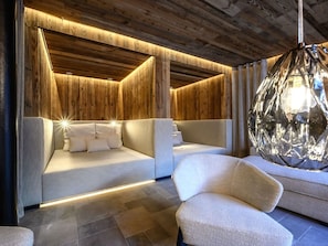 Ein modernes Schlafzimmer mit Holzboden, einem Bett mit weißer Bettwäsche und einer Hängelampe.