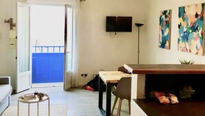 Una sala de estar moderna con un sofá, una mesa de centro, un televisor montado en la pared y arte abstracto.