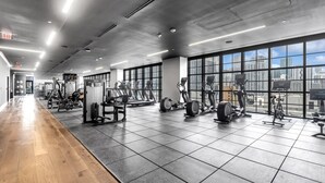 A gym with cardio machines, weight stations, and a wooden floor. - Sky-High Views & Pool – Steps from Miami Arena (Miami)