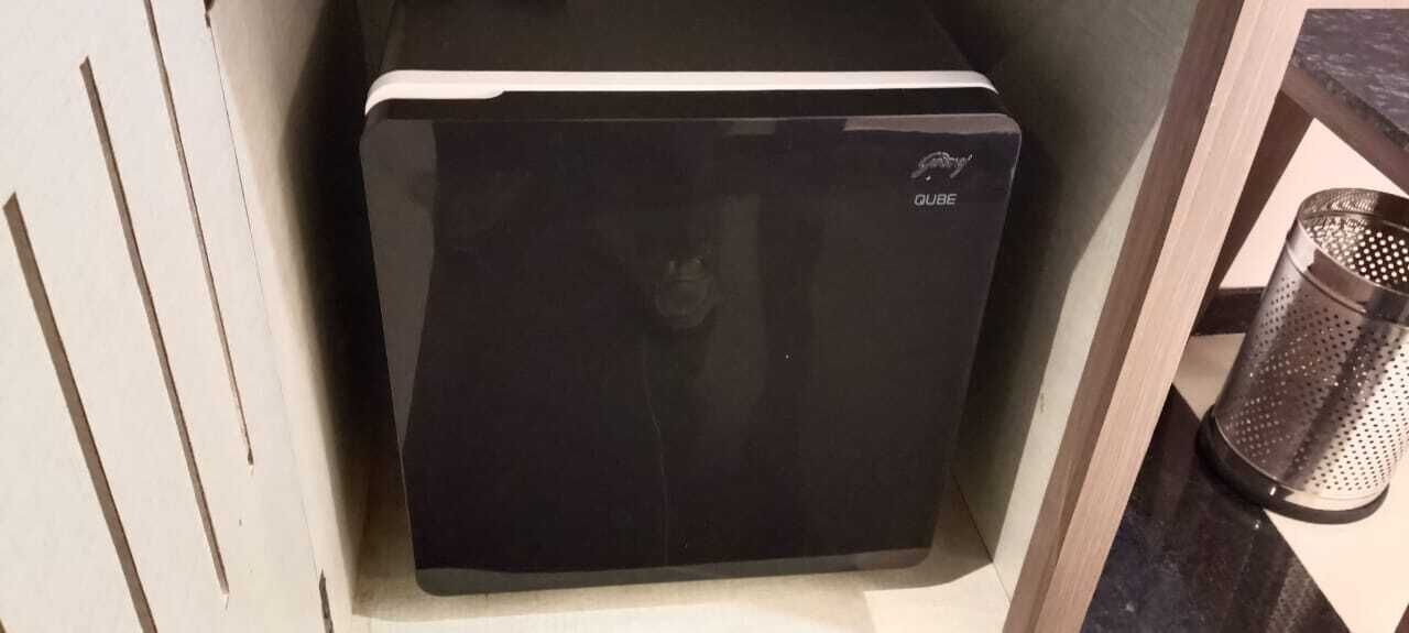 A black refrigerator with the brand name 'QUEBE' visible on the front.