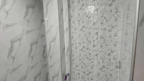 A bathroom with a toilet, a shower, and a toilet paper holder. - Charming Room in Delightful Compostela with Free Breakfast & Outdoor Seating  (Compostela)