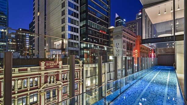 Un bâtiment moderne doté d’un atrium en verre et d’un espace piscine.