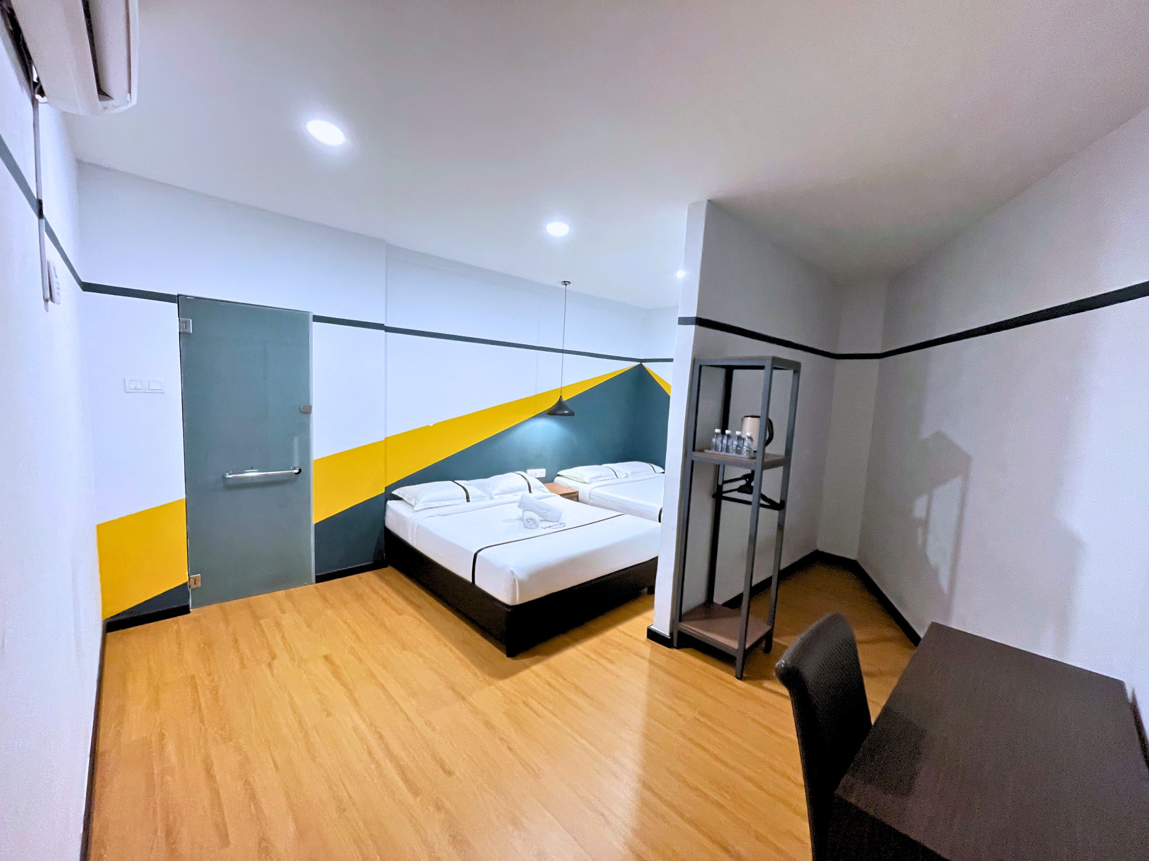 A hotel room with a bed, a desk, and a wardrobe.