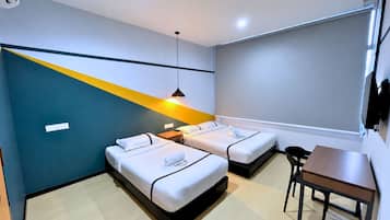 A hotel room with two beds, a desk, a chair, and a modern pendant light.