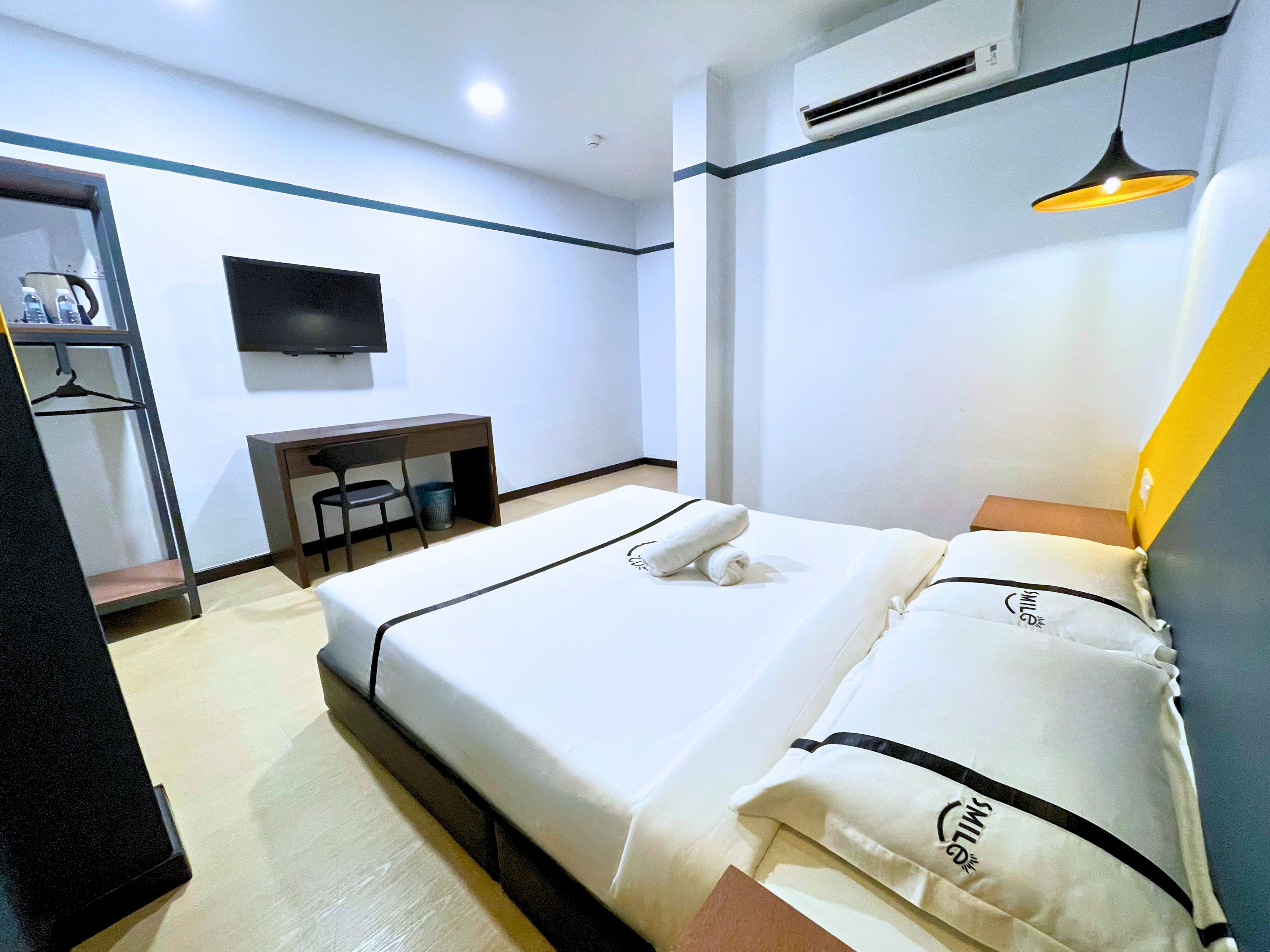 Une chambre d’hôtel équipée d’un lit, d’un bureau, d’une chaise, d’une télévision et d’un appareil de climatisation.