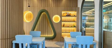 A modern interior with wooden panel walls, a unique geometric light fixture, and a display of toys.