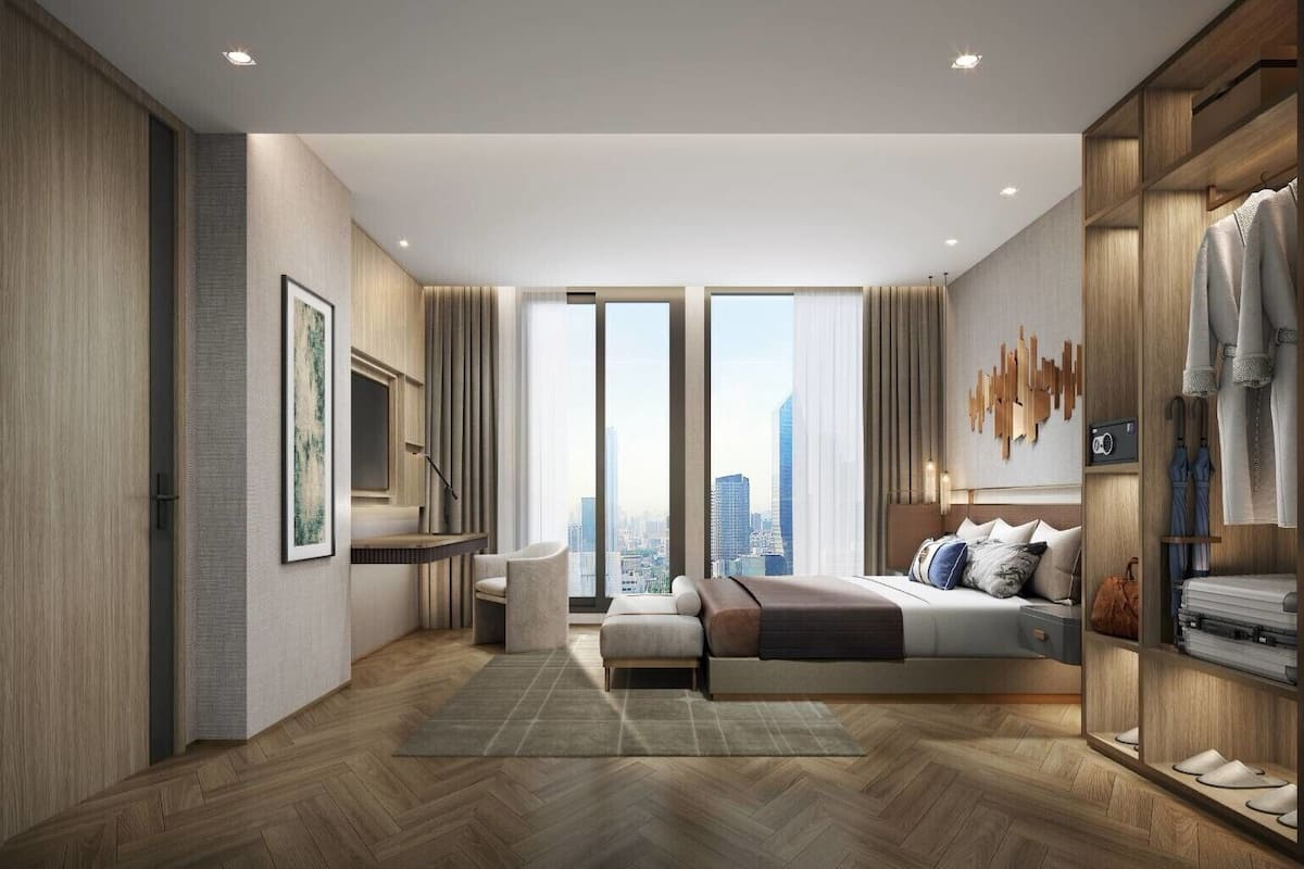 Een moderne hotelkamer met een groot bed, zithoek en uitzicht op de stadshemel.