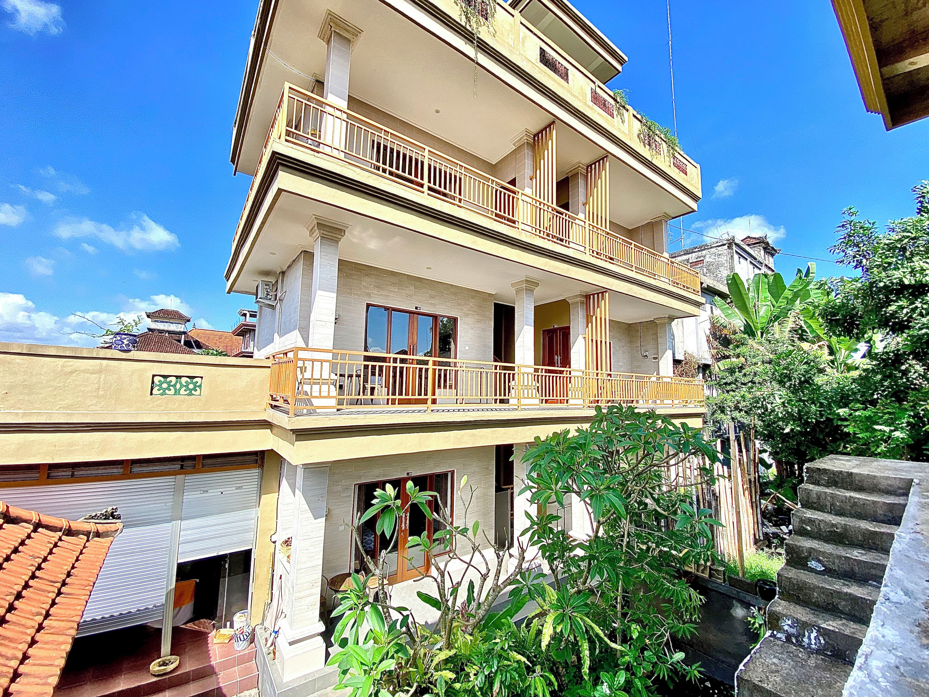 A multi-story residential building with balconies, a garage, and a staircase.