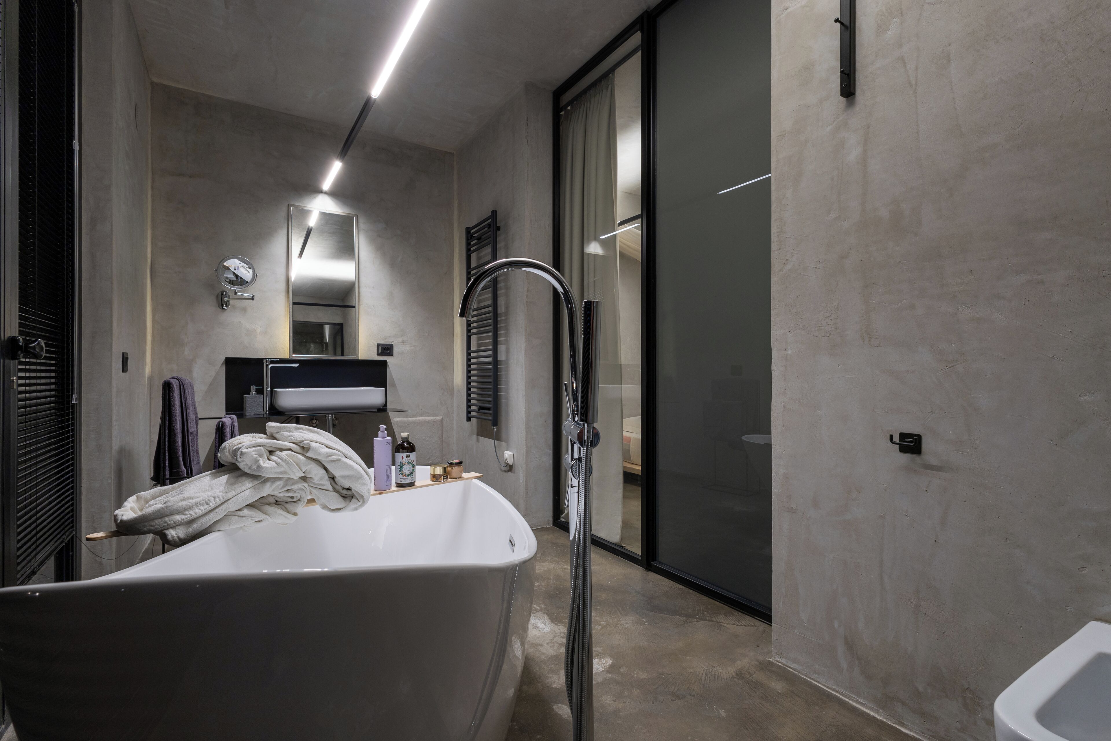 A modern bathroom with a freestanding bathtub, a glass shower enclosure, and a vanity with a mirror.