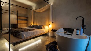 Un dormitorio moderno con cama, mesita de noche y una bañera grande.