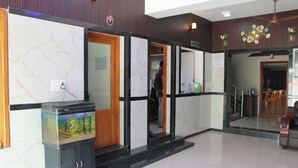 Een receptie met een marmeren wand, een aquarium en een trap naar een tweede verdieping.