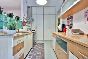 Una cucina con isola centrale, mobili e pavimento piastrellato.
