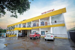 Un edificio de varios pisos con fachada amarilla y blanca, llamado "YATRI NIMAS".