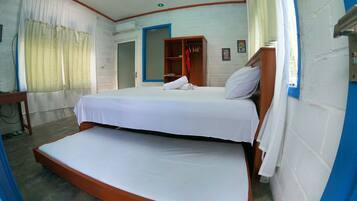 Een kamer met een bed, een kledingkast, een bureau en een raam met gordijnen.