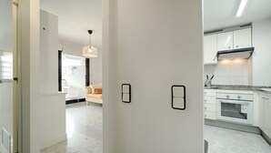 Una cocina moderna con armarios blancos, horno integrado y encimera de mármol.