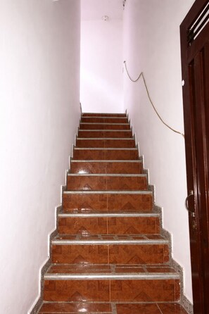 A staircase with a handrail, leading to a door with a keyhole.