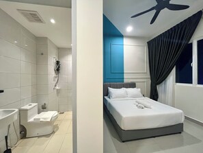 A modern hotel room with a shower, toilet, and a bed with white linens and a grey headboard. - Amber Cove Melaka by Manhattan Group (Malacca City)