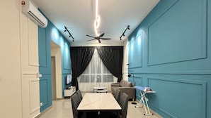 Ein stilvoller Essbereich mit Tisch, Stühlen, Deckenventilator und Fernseher an der Wand.