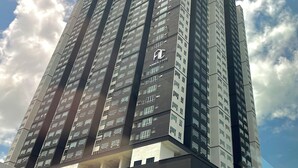Ein Hochhaus mit mehreren Stockwerken, das ein modernes architektonisches Design und ein auffälliges Logo an der Seite aufweist.