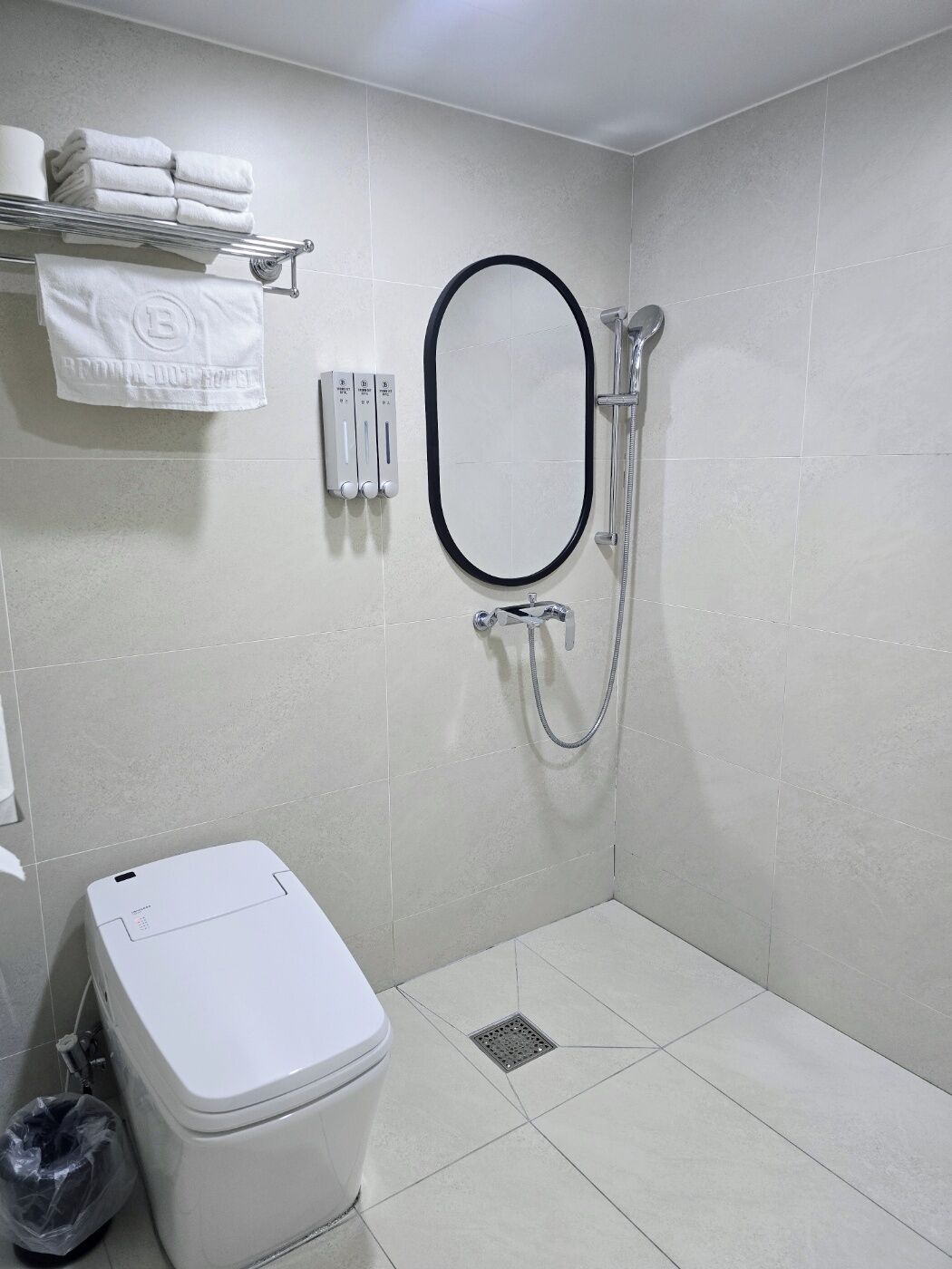 Un bagno piccolo e moderno con doccia, toilette e porta asciugamani.