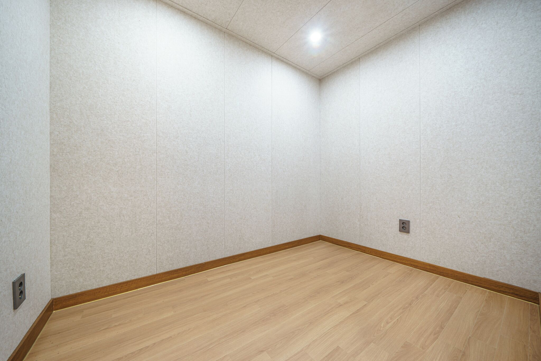 A room with a wooden floor and white textured walls.