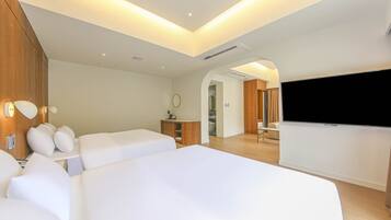 A modern hotel room with two large beds, a TV, a desk, and a walk-in closet.