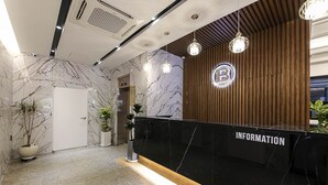 A reception area with a marble wall, a wooden panel wall, and a reception desk labeled "INFORMATION". - Browndot Hotel Mokpo Gotbawi (Mokpo)