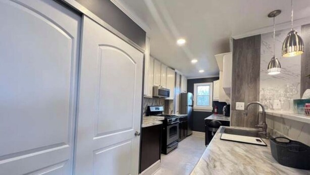 A modern kitchen with white cabinetry, a marble countertop, and a built-in oven. - Spacious DC Getaway • Modern Comfort • Walk-In Shower • Near Metro (Washington)