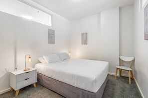 Relax in this serene bedroom with a single bed, bedside table, and stylish lamp.