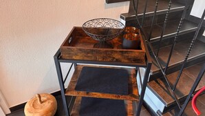 A wooden side table with a metal frame and a black mat, placed near a staircase. - Time out at the mountain spring with 2 bedrooms, bathroom with shower/WC and terrace (Schönau am Königssee)