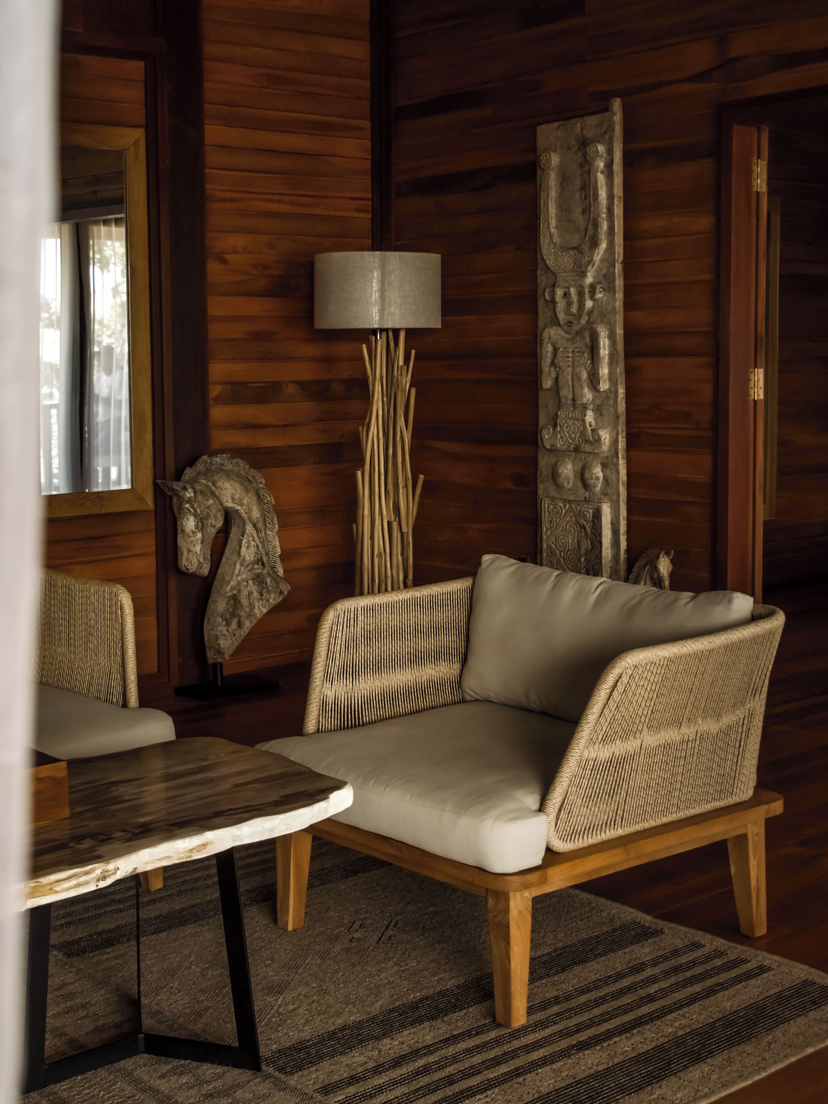 Una habitación con sofá, lámpara, alfombra y paneles de madera.