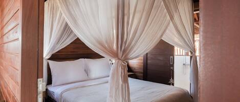A bed with a canopy, wooden walls, and a nightstand with a lamp.