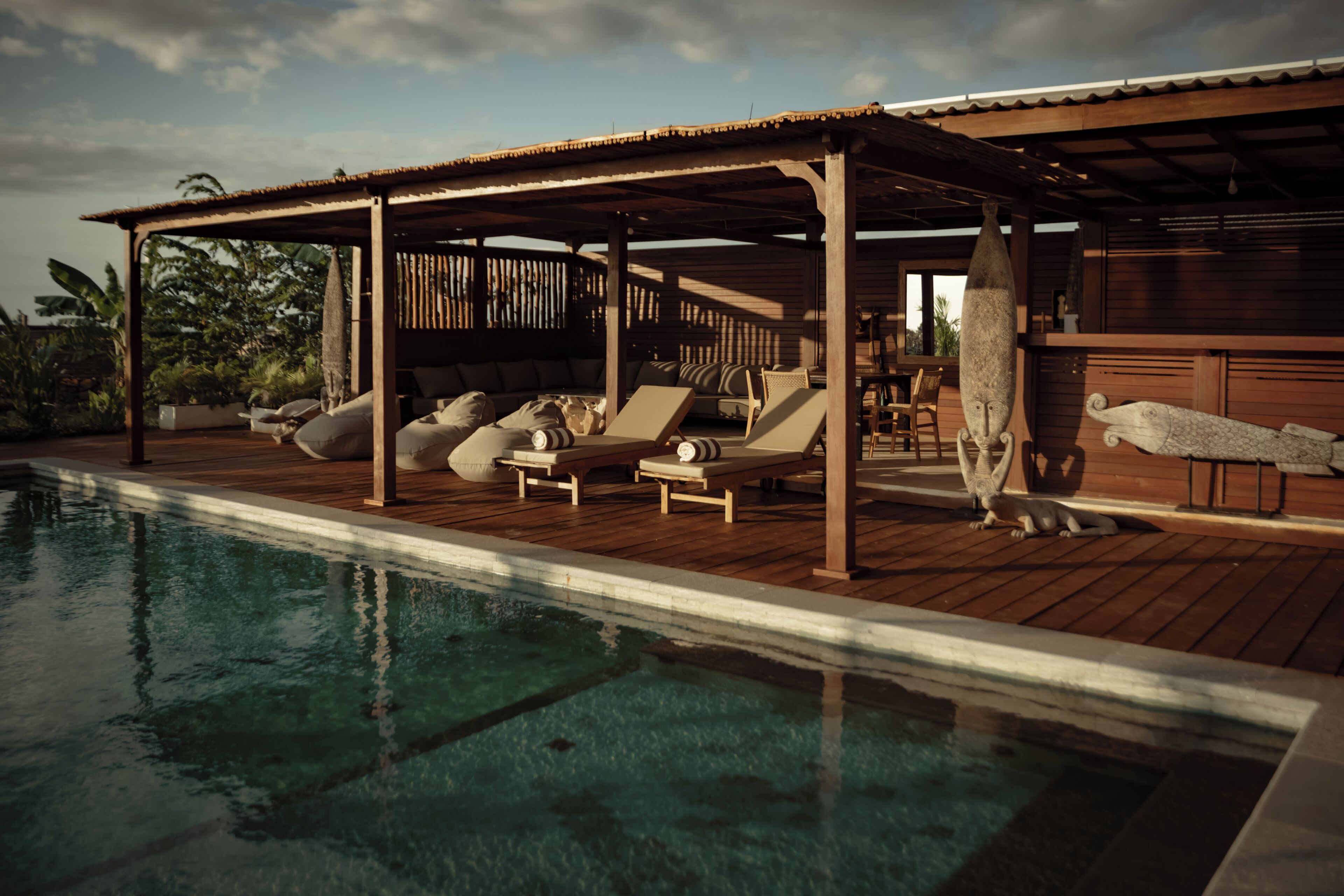 A poolside area with lounge chairs and a wooden deck.