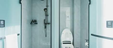 A modern bathroom with a glass partition, a shower, and a toilet.
