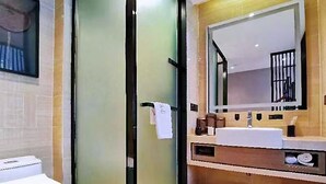 A modern bathroom with a glass shower door, a white toilet, and a sink with a mirror above it. - Yuan Culture Hotel Shenzhen (Shenzhen)