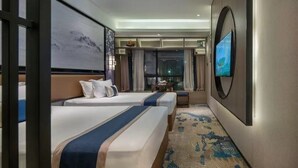 A hotel room with two beds, a large TV, a painting, and a view of the city at night. - Yuan Culture Hotel Shenzhen (Shenzhen)