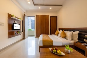 Ein Hotelzimmer mit Bett, Nachttisch, Fernseher und Balkonblick.
